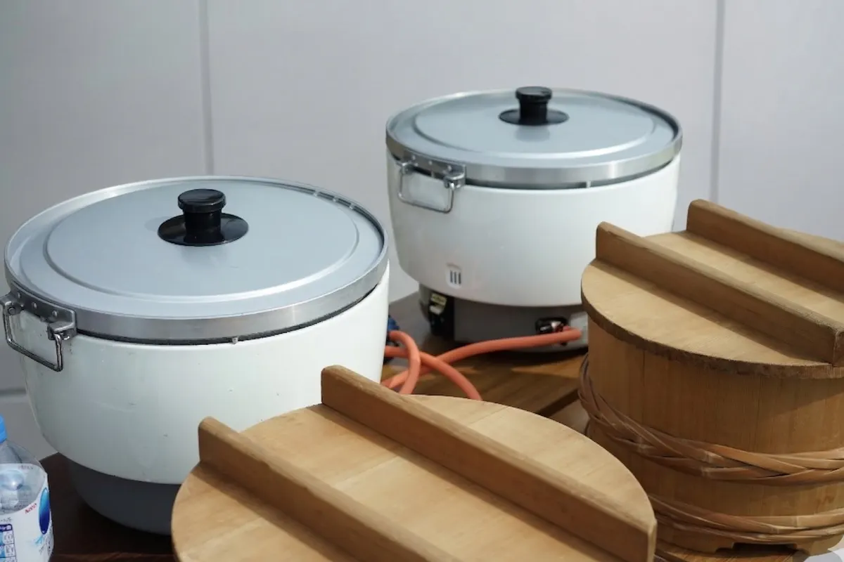業務用の炊飯器2台と、木のおひつのふた